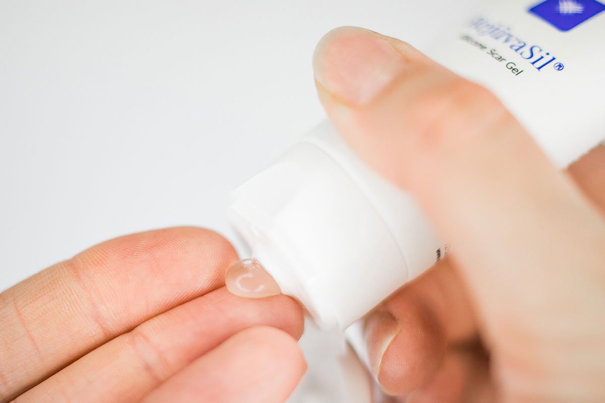 Person applying RejuvaSil silicone scar gel to a fingertip