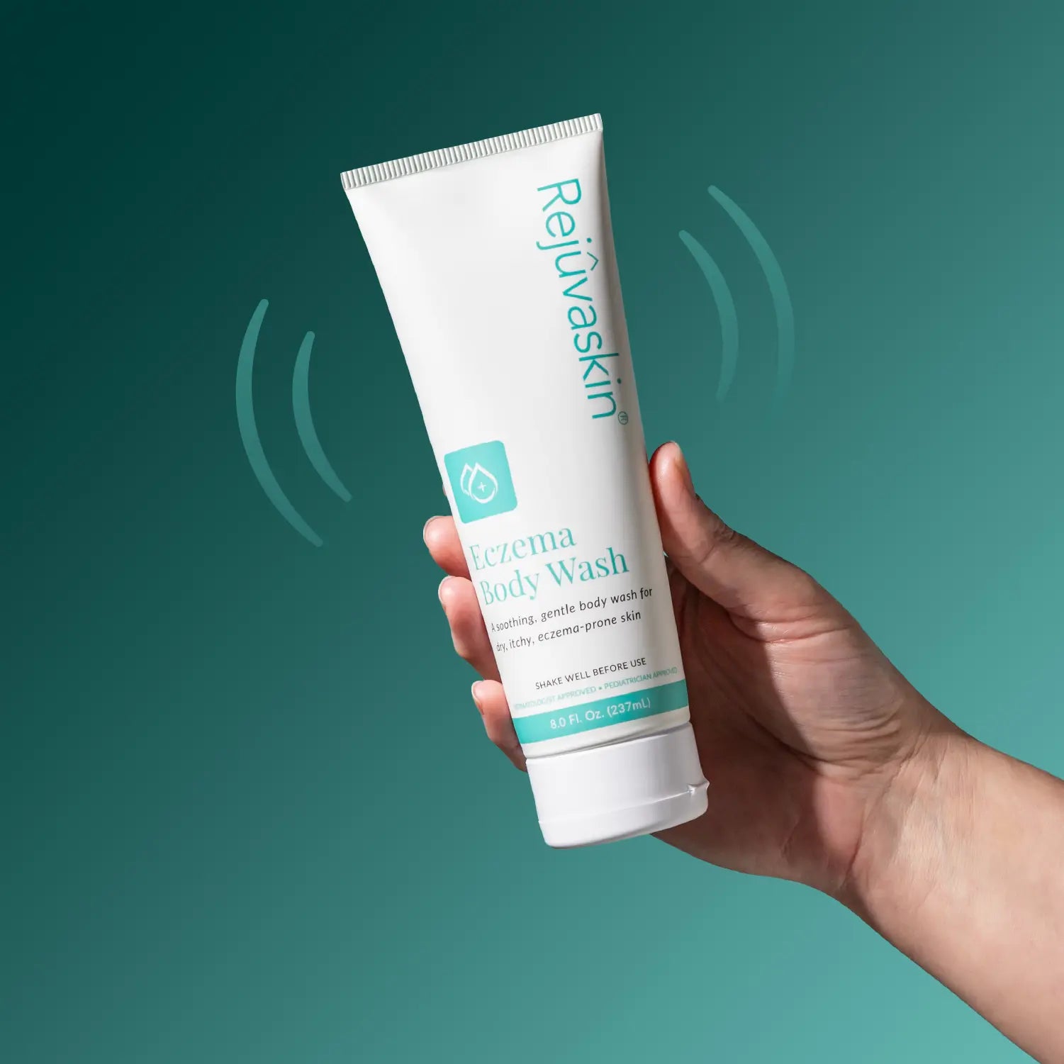 A hand holding a white tube of Rejuvaskin Eczema Body Wash against a teal gradient background with subtle wave graphics.